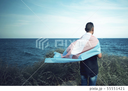 young person with a transgender pride flag. 55551421