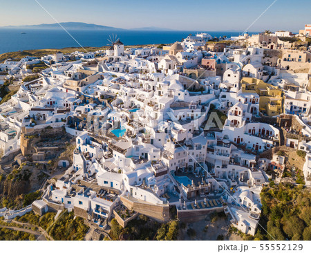 Aerial view of Santorini island, Greece, Oia village with windmills and white houses. Amazing sunset 55552129