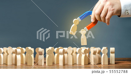 Businessman with a magnet pulls wooden figures 55552788