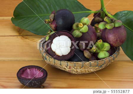 Ripe mangosteens (Garcinia mangostana) with green Ripe mangosteens (Garcinia mangostana) with green 55552877