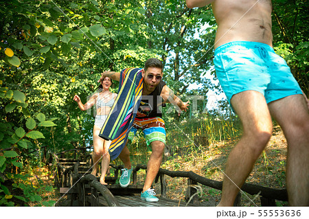 Group of happy friends having fun while running to swim on river 55553636
