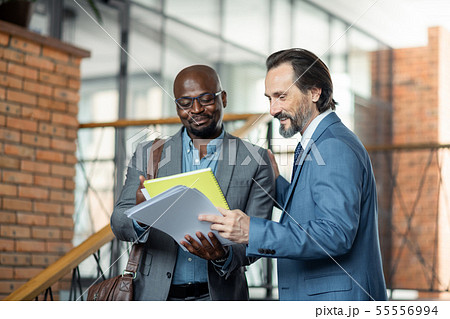 Grey-haired boss feeling satisfied with work of his employee Grey-haired boss feeling satisfied with work of his employee 55556994