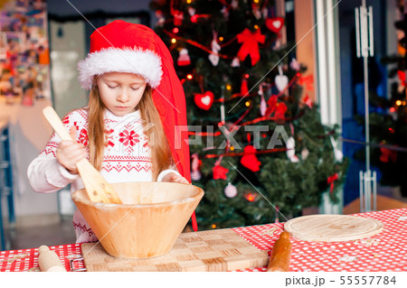 Adorable little girl baking Christmas gingerbread cookies Adorable little girl baking Christmas gingerbread cookies 55557784