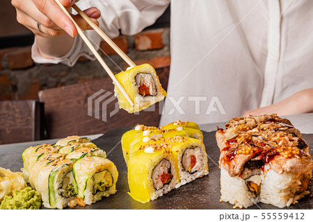 woman eating sushi in the restaurant woman eating sushi in the restaurant 55559412