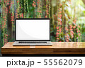 Laptop blank screen on wooden table red flowers 55562079