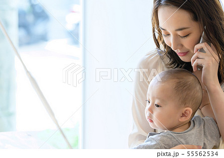子供を抱きながら電話をする女性 55562534