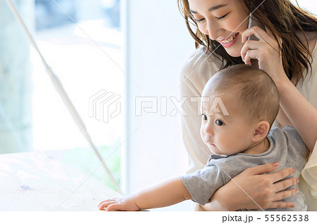 子供を抱きながら電話をする女性 55562538