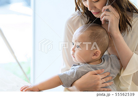 子供を抱きながら電話をする女性 55562539