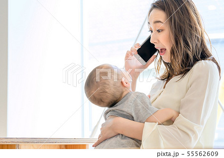 子供を抱きながら電話をする女性 55562609