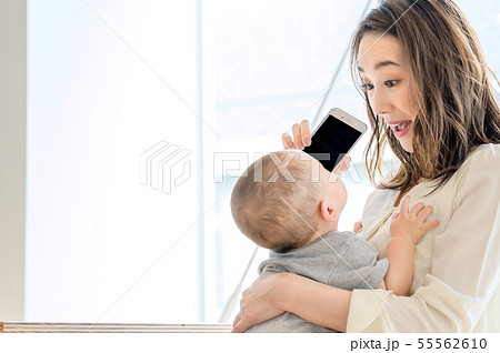 子供を抱きながら電話をする女性 55562610