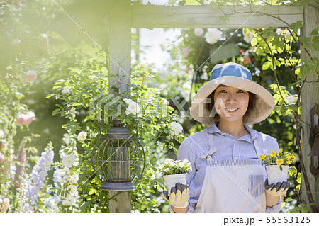ガーデニングイメージ 花の苗を持つ女性 カメラ目線の写真素材
