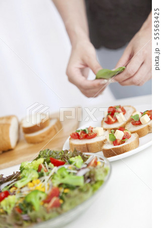 料理の盛り付けをする手元 55563425