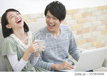 ノートパソコンを見て笑う夫婦 55564090