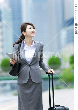スーツケースを持ったビジネスウーマンの写真素材