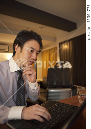 ホテルの部屋でパソコンを操作する男性 55564773