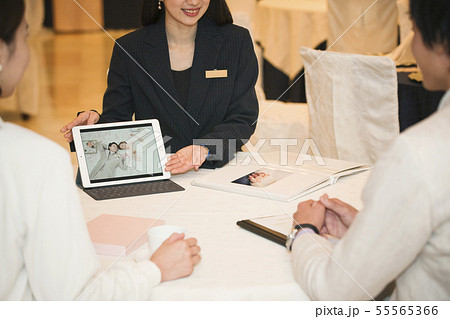 打ち合わせをするウエディングプランナーとカップル 55565366