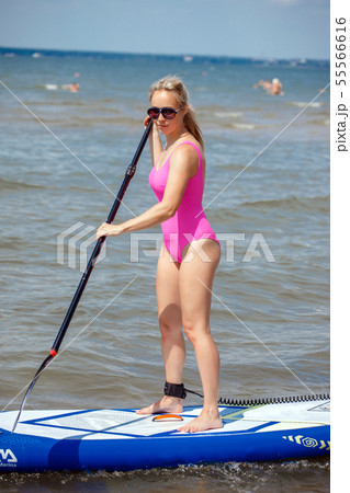 Young athletic woman in bright pink swimsuit doing 55566616
