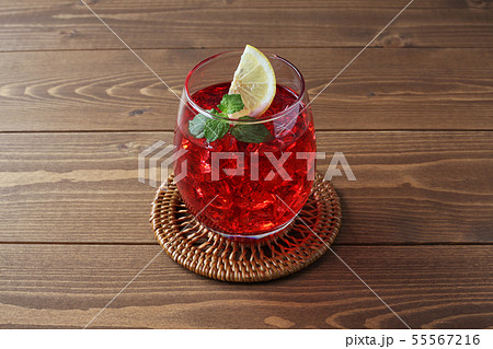 氷を入れた アイスティー 紅茶 赤い飲み物 グラス テーブルの写真素材
