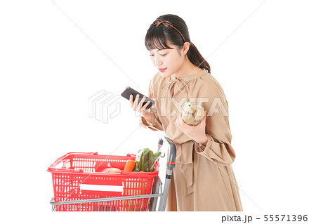 スーパーで食品の原産地を調べる若い女性 55571396