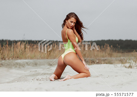 Seductive woman in stylish swimsuit kneeling in 55571577