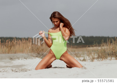 Seductive woman in stylish swimsuit kneeling in 55571581