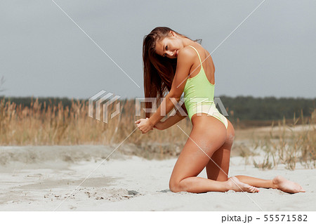 Seductive woman in stylish swimsuit kneeling in 55571582