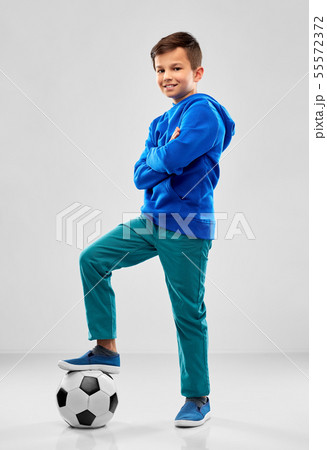 smiling boy in blue hoodie with soccer ball 55572372