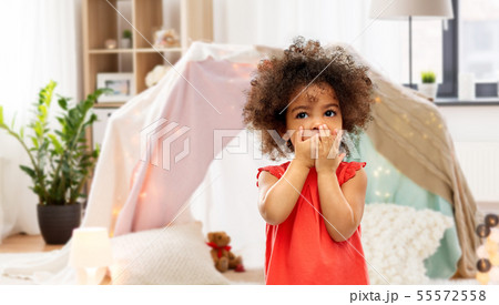 confused african american girl covering mouth confused african american girl covering mouth 55572558