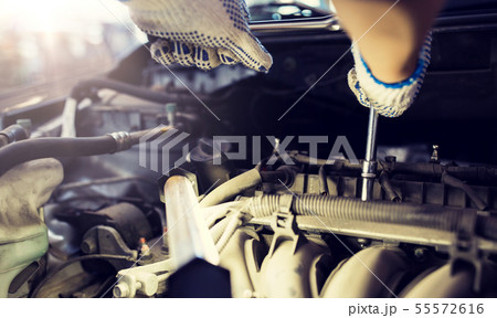 mechanic man with wrench repairing car at workshop mechanic man with wrench repairing car at workshop 55572616