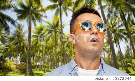 surprised man in sunglasses over tropical beach surprised man in sunglasses over tropical beach 55572644
