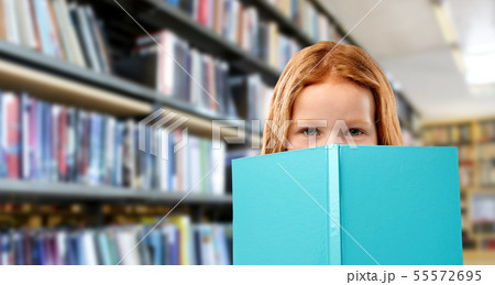 smiling red haired girl reading book at library smiling red haired girl reading book at library 55572695