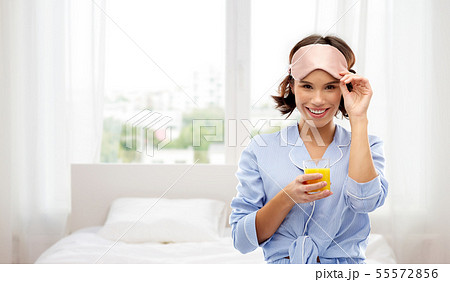 woman in pajama and sleeping mask with juice woman in pajama and sleeping mask with juice 55572856