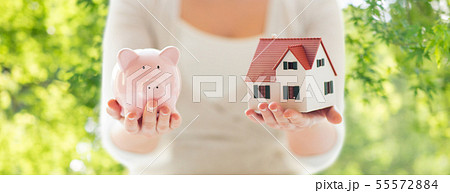 close up of woman with house model and piggy bank close up of woman with house model and piggy bank 55572884