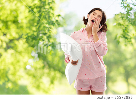 sleepy yawning young woman in pajama with pillow 55572885