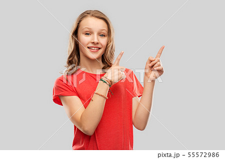 smiling teenage girl pointing fingers to something 55572986
