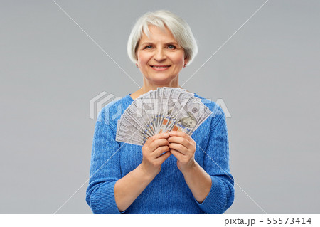 senior woman with hundred dollar money banknotes 55573414