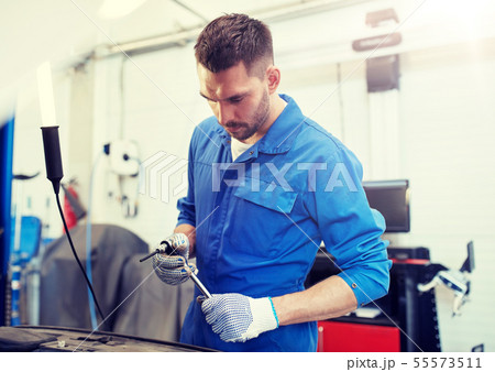 mechanic man with wrench repairing car at workshop mechanic man with wrench repairing car at workshop 55573511