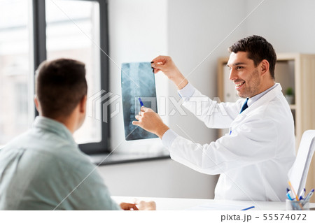 doctor showing x-ray to patient at hospital 55574072