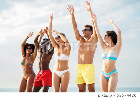 happy friends with hands up on summer beach 55574420