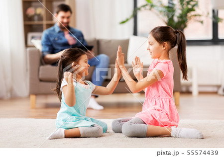 happy little sisters playing clapping game at home happy little sisters playing clapping game at home 55574439