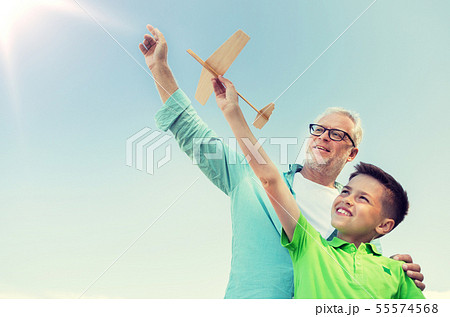 senior man and boy with toy airplane over sky senior man and boy with toy airplane over sky 55574568