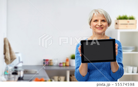senior woman using tablet computer in kitchen senior woman using tablet computer in kitchen 55574598