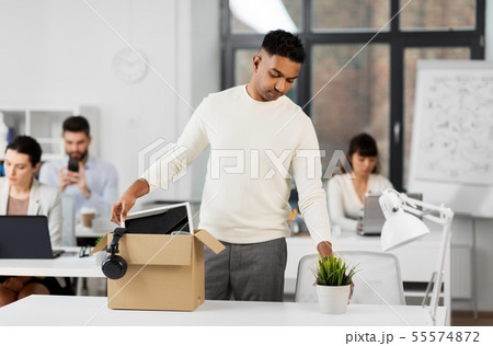sad fired office worker packing personal stuff sad fired office worker packing personal stuff 55574872