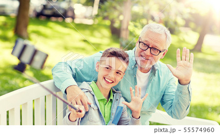 old man and boy taking selfie by smartphone old man and boy taking selfie by smartphone 55574960