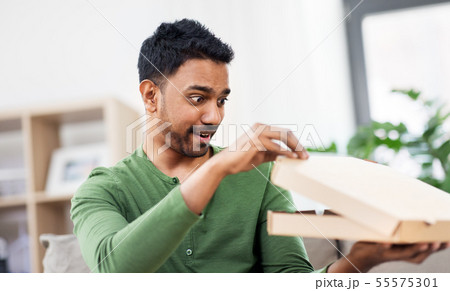 indian man looking inside of takeaway pizza box indian man looking inside of takeaway pizza box 55575301