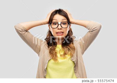 asian female student in glasses holding to head asian female student in glasses holding to head 55575474