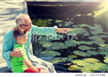 grandfather and grandson sitting on river berth 55575490
