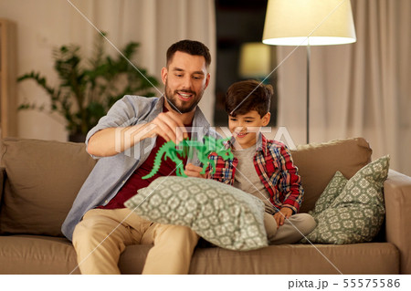 father and son playing with toy dinosaur at home father and son playing with toy dinosaur at home 55575586