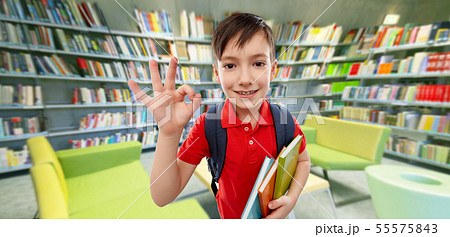 student boy with books showing ok at library student boy with books showing ok at library 55575843