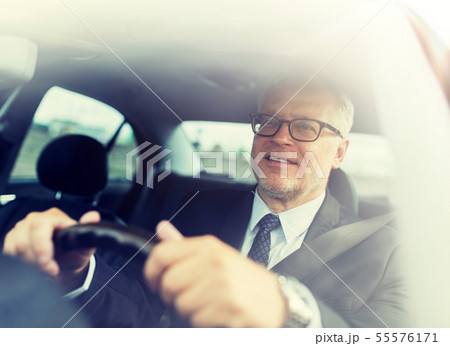 happy senior businessman driving car 55576171